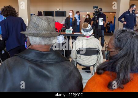 Detroit, Michigan, USA. Februar 2021, 27th. Patienten sitzen im Beobachtungsgebiet, nachdem sie gegen das Coronavirus geimpft wurden, in einer der Wochenend-Gemeinschaftskliniken des Detroit Health Department. Sie müssen dort 15-30 Minuten warten, um sicherzustellen, dass sie nicht von ernsthaften Nebenwirkungen leiden. Kredit: Jim West/Alamy Live Nachrichten Stockfoto