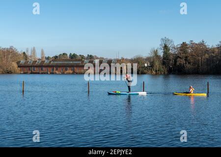 Paddelboarding auf dem Mytchett Lake in Surrey, England, an einem sonnigen Wintertag Stockfoto