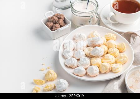 Französische Meringues in gelb und weiß auf hellem Hintergrund. Stockfoto
