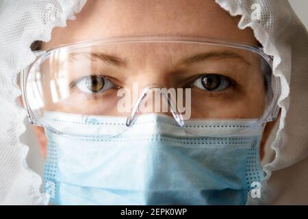 Arzt oder Krankenschwester in Berufskanzügen wegen COVID-19 Coronavirus-Pandemie, Porträt des Arztes in persönlicher Schutzausrüstung (PSA) Nahaufnahme, Augen Stockfoto
