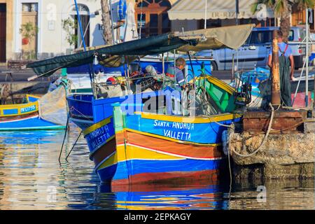 Fischer, die ein luzzu (Maltesisches traditionelles Fischerboot) für einen Angelausflug in der Marina von Marsaxlokk, Malta vorbereiten Stockfoto