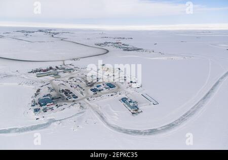 Luftaufnahme des Industriegebiets der Inuvialuit Gemeinde Tuktoyaktuk, umgeben vom gefrorenen Arktischen Ozean, Nordwest-Territorien, Kanada. Stockfoto