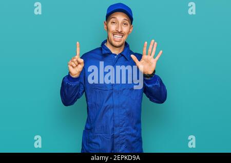 Glatze Mann mit Bart tragen Baumeister Jumpsuit Uniform zeigt und zeigt mit den Fingern Nummer sechs, während lächelnd zuversichtlich und glücklich. Stockfoto