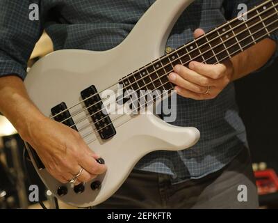 Gitarrist spielt Bassgitarre, Musiker zupft Strings of Musical Instrument, Bassist Band Member Creating Music, Jamming Session Stockfoto