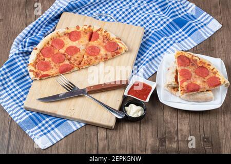 Blick von oben auf köstliche Pepperoni Pizza Scheiben auf Holz Hintergrund Stockfoto