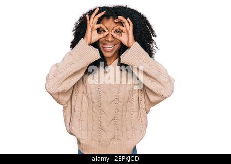 Junge afroamerikanische Mädchen tragen Freizeitkleidung tun ok Geste wie Fernglas aufragende Zunge aus, Augen durch die Finger schauen. Crazy expressio Stockfoto