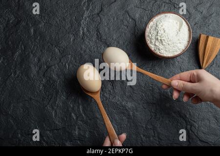 Weibliche Hände halten Löffel Eier Stockfoto