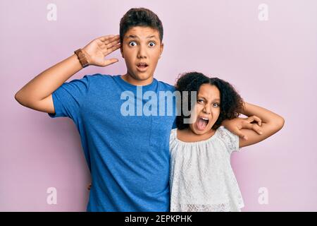 Junge hispanische Familie von Bruder und Schwester tragen Casual Kleidung zusammen verrückt und verängstigt mit den Händen auf dem Kopf, Angst und überrascht von Schock mit op Stockfoto
