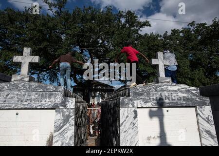 Junge Männer tanzen auf Gräbern und Gräbern auf dem Friedhof während Prince of Wales, New Orleans Social Aid and Pleasure Club Second Line (Second Line). Stockfoto