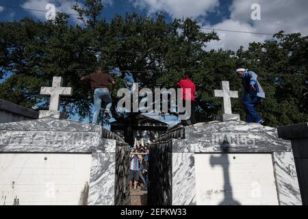 Junge Männer tanzen auf Gräbern und Gräbern auf dem Friedhof während Prince of Wales, New Orleans Social Aid and Pleasure Club Second Line (Second Line). Stockfoto