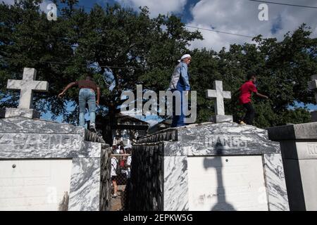 Junge Männer tanzen auf Gräbern und Gräbern auf dem Friedhof während Prince of Wales, New Orleans Social Aid and Pleasure Club Second Line (Second Line). Stockfoto