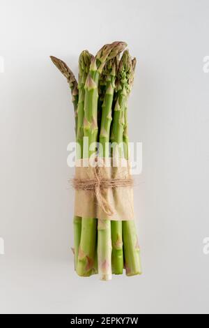 Ein Bündel von schönen rohen grünen Spargel auf weißem Hintergrund, Kopierraum, vertikal Stockfoto