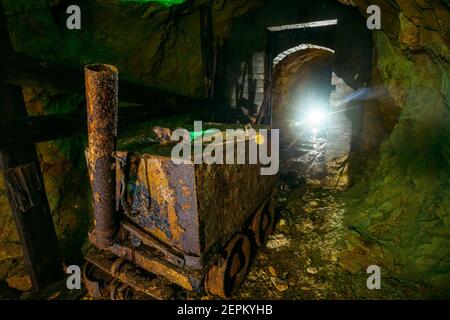 Schmutzige verlassene Uranmine mit rostiger Schiene und Rollwagen. Stockfoto