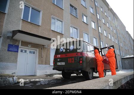 Zwei medizinische Mitarbeiter, die Anzüge zum Schutz vor Coronaviren tragen, helfen einer älteren Frau, die an COVID-19 leidet, einen Krankenwagen in ein Krankenhaus in Bohorodchany, Westukraine, zu verlassen. Nach mehreren Verzögerungen erhielt die Ukraine schließlich 500.000 Dosen des Impfstoffs AstraZeneca, der unter dem Namen CoviShield vermarktet wird, die erste Lieferung von Impfdosen Covid-19. Die Ukraine ist eine der letzten in der Region, die mit der Impfung ihrer Bevölkerung beginnt. Stockfoto