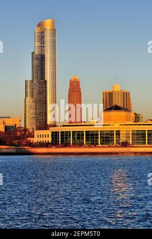 Chicago, Illinois, USA. Die aufgehende Sonne über dem Lake Michigan spiegelt sich vom Adler Planetarium und einem Teil der Skyline von South Loop wider. Stockfoto