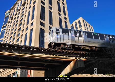 Chicago, Illinois, USA. Ein CTA-Hochzug befährt seinen Weg durch eine Kurve und um Gebäude auf dem Weg zur Wabash Avenue im Chicago Loop. Stockfoto