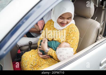 Kleiner Junge mit ihrer muslimischen Mutter im Auto gehen Für eine Reise Stockfoto