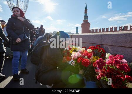 Moskau, Russland. Februar 2021, 27th. Eine Frau, die während der Gedenkfeier Blumen legt. Mehr als 10 Tausend Menschen nahmen am Gedenken an Boris Nemzow am sechsten Jahrestag der Ermordung des Politikers Teil. Unter ihnen sind der ehemalige Ministerpräsident Michail Kasjanow, die Politiker Ilja Jaschin, Dmitri Gudkow, Grigori Jawlinski und Julia Galyamina, die politischen Gefangenen Konstantin Kotow und Anna Pawlikowa und Julia Nawalnaja. Kredit: SOPA Images Limited/Alamy Live Nachrichten Stockfoto