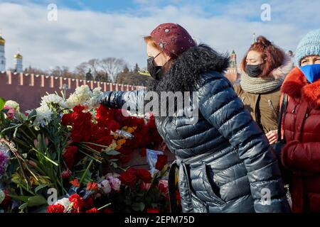 Moskau, Russland. Februar 2021, 27th. Frauen legen Blumen während der Gedenkstätte. Mehr als 10 Tausend Menschen nahmen am Gedenken an Boris Nemzow am sechsten Jahrestag der Ermordung des Politikers Teil. Unter ihnen sind der ehemalige Ministerpräsident Michail Kasjanow, die Politiker Ilja Jaschin, Dmitri Gudkow, Grigori Jawlinski und Julia Galyamina, die politischen Gefangenen Konstantin Kotow und Anna Pawlikowa und Julia Nawalnaja. Kredit: SOPA Images Limited/Alamy Live Nachrichten Stockfoto