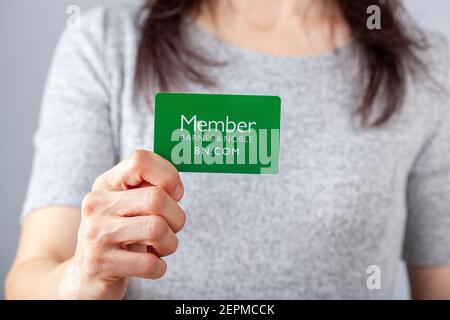 02-24-2021 Clarksburg, MD, USA: Eine junge Kaukasierin hält eine grüne Karte, die Barnes and Noble-Mitglied darauf sagt. Als Mitglied, Mitgliedschaft du Stockfoto