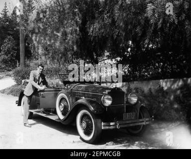 GARY COOPER posiert Anfang 1930 neben seinem neuen Gekauft 1929 PACKARD 640 Sport 5 Person phaeton Automobil / Auto Werbung für Paramount Pictures Stockfoto