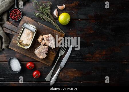 Dose Wild Pink Lachs Set, auf Holzschneidebrett, auf altem dunklen Holztischhintergrund mit Kräutern und Zutaten, Draufsicht flach liegend, mit Copyspac Stockfoto