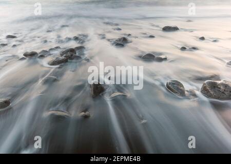 Große Kieselsteine mit Wellen auf dem wilden Atlantik Strand auf der Insel Madeira Stockfoto