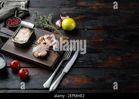 Dosen Wild Pink Lachs Set, auf Holz Schneidebrett, auf alten dunklen Holztisch Hintergrund mit Kräutern und Zutaten, mit Copyspace und Platz für tex Stockfoto