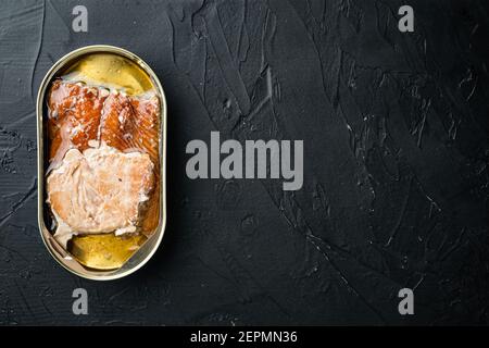 Wild Pink Salmon Räucherfisch-Set aus Dosen, in Blechdose, auf schwarzem Hintergrund, Draufsicht flach liegend, mit Textraum und Platz für Text Stockfoto