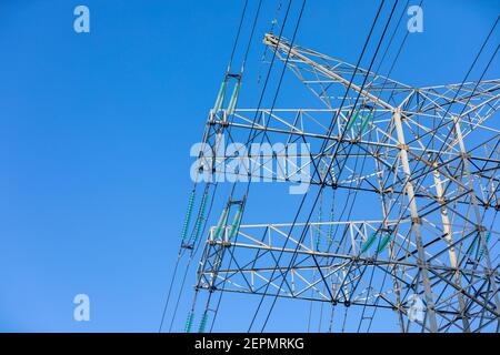 Neuer großer Mast einer Luftstromleitung aus der Nähe, Hochspannungsmast mit dicken Drähten und Isolatoren, blauer Himmel auf dem Hintergrund. Traditionell Stockfoto