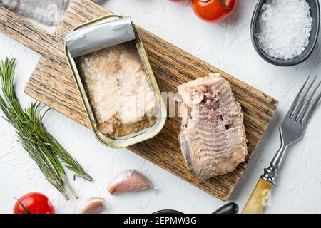 Dosen Wild Alaska Lachs Set, auf Holzschneidebrett, auf weißem Hintergrund mit Kräutern und Zutaten, Draufsicht flach legen Stockfoto