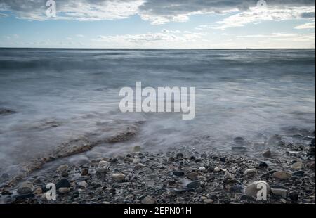 Seeschiffe planschen mit Steinen an die Küste gegen den stürmischen dramatischen Wolkenhimmel. Winterzeit, Limassol zypern Stockfoto