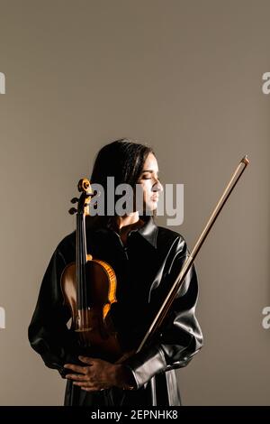 Geigerin stehend mit Musikinstrument und nachdenklich geschlossenen Augen Stockfoto