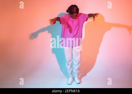 Ganzer Körper von afroamerikanischen Teenager-Mädchen Performing Urban Dance Bewegung im hellen Studio Stockfoto