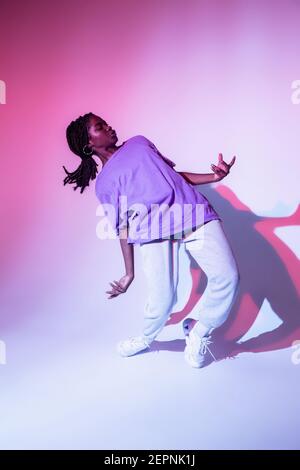 Ganzer Körper von afroamerikanischen Teenager-Mädchen Performing Urban Dance Bewegung im hellen Studio Stockfoto