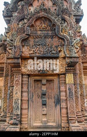 Die Gebäude im Tempel des Banteay Srei aus dem 10th. Jahrhundert sind mit kunstvoll geschnitzten Darstellungen des hinduistischen Ramayana-Epos in rosa Sandstein bedeckt. Stockfoto