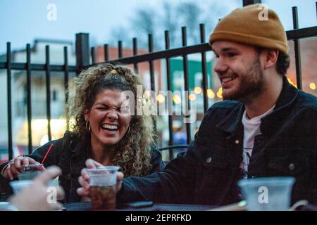 Athen, Usa. Februar 2021, 27th. Die Schüler genießen ihre Getränke zusammen auf der Terrasse vor Courtside Pizza. Während das Wetter in Ohio aufwärmt Studenten von der Ohio University Kopf zur Court Street, um an Bars zu sozialisieren. Die Impfstoffverteilung ist in Ohio noch im Gange, aber für Studenten, die nicht mit vielen Personen außerhalb ihrer Kohorte interagieren, hat die Bedrohung durch die Coronavirus-Krankheit (COVID-19) sie nicht davon abgehalten, eine Nacht in der Stadt zu verbringen. Kredit: SOPA Images Limited/Alamy Live Nachrichten Stockfoto