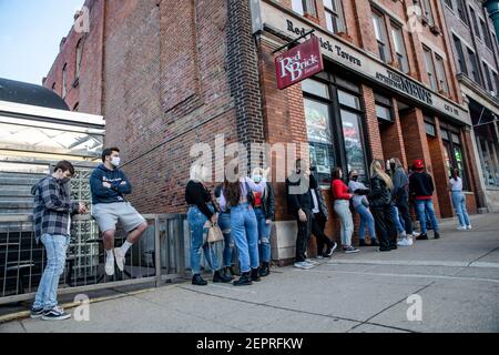 Athen, Usa. Februar 2021, 27th. Die Schüler warten darauf, die Red Brick Tavern zu betreten. Während das Wetter in Ohio aufwärmt Studenten von der Ohio University Kopf zur Court Street, um an Bars zu sozialisieren. Die Impfstoffverteilung ist in Ohio noch im Gange, aber für Studenten, die nicht mit vielen Personen außerhalb ihrer Kohorte interagieren, hat die Bedrohung durch die Coronavirus-Krankheit (COVID-19) sie nicht davon abgehalten, eine Nacht in der Stadt zu verbringen. Kredit: SOPA Images Limited/Alamy Live Nachrichten Stockfoto