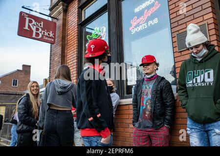 Athen, Usa. Februar 2021, 27th. Die Schüler warten darauf, die Red Brick Tavern zu betreten. Während das Wetter in Ohio aufwärmt Studenten von der Ohio University Kopf zur Court Street, um an Bars zu sozialisieren. Die Impfstoffverteilung ist in Ohio noch im Gange, aber für Studenten, die nicht mit vielen Personen außerhalb ihrer Kohorte interagieren, hat die Bedrohung durch die Coronavirus-Krankheit (COVID-19) sie nicht davon abgehalten, eine Nacht in der Stadt zu verbringen. Kredit: SOPA Images Limited/Alamy Live Nachrichten Stockfoto