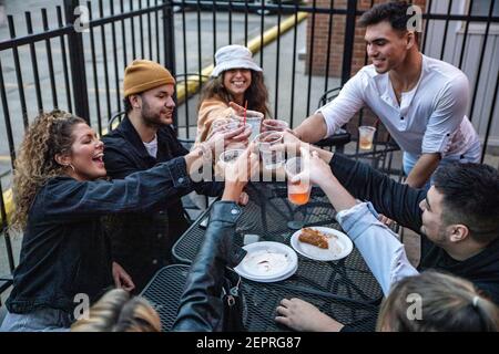 Athen, Usa. Februar 2021, 27th. Eine Gruppe von Freunden genießen Getränke auf der Terrasse vor Courtside Pizza. Während das Wetter in Ohio aufwärmt Studenten von der Ohio University Kopf zur Court Street, um an Bars zu sozialisieren. Die Impfstoffverteilung ist in Ohio noch im Gange, aber für Studenten, die nicht mit vielen Personen außerhalb ihrer Kohorte interagieren, hat die Bedrohung durch die Coronavirus-Krankheit (COVID-19) sie nicht davon abgehalten, eine Nacht in der Stadt zu verbringen. Kredit: SOPA Images Limited/Alamy Live Nachrichten Stockfoto