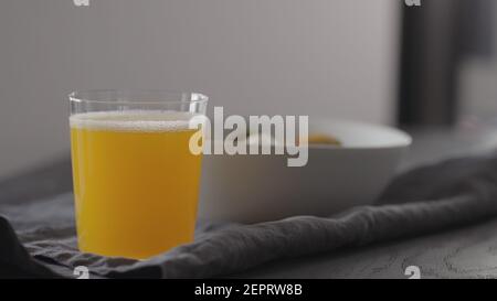 Orangefarbene Limonade aus Glas auf schwarzem Holztisch, flacher Fokus Stockfoto