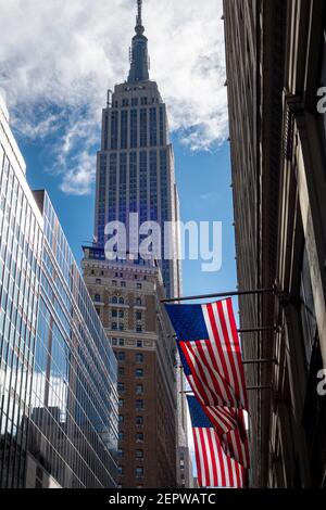 USA-Flaggen mit Empire State Building im Hintergrund, in Manhattan, New York Stockfoto