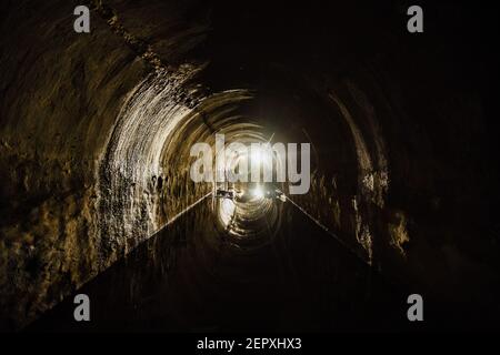Überfluteter gewölbter Kanaltunnel mit Wasserspiegelung. Stockfoto