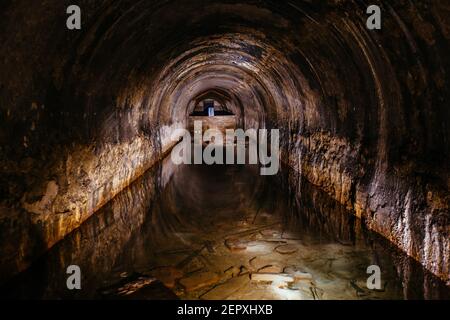 Überfluteter gewölbter Kanaltunnel mit Wasserspiegelung. Stockfoto