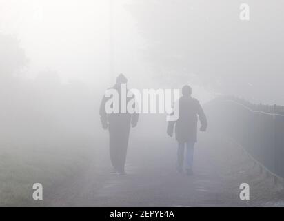 Crosshaven, Cork, Irland. 28th. Februar 2021. Zwei Männer machen einen Spaziergang in Camden, Crosshaven, Co. Cork, Irland, am frühen Morgen bei starkem Nebel. - Credit; David Creedon / Alamy Live News Stockfoto