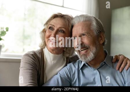 Nachdenkliche ältere Rentnerfamilie Paar wegschauen und lächeln Stockfoto