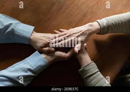 Frau mittleren Alters hält die Hände von geliebten reifen Ehemann Stockfoto