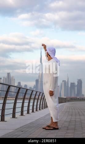 emirati man in Al Jaddaf Waterfront in Dubai mit Burj Khalifa im Hintergrund Stockfoto