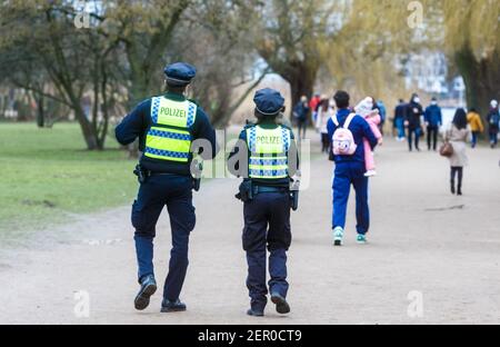 Hamburg, Deutschland. Februar 2021, 28th. Polizeibeamte patrouillieren um die Außenalster Hamburgs, um die seit Samstag in Kraft getretene erweiterte Maskenpflicht durch direkte Ansprache zu überprüfen und durchzusetzen. Quelle: Markus Scholz/dpa/Alamy Live News Stockfoto