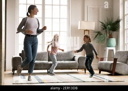 Glücklich aktive Mutter und aufgeregt Vorschulkinder Geschwister tanzen Stockfoto